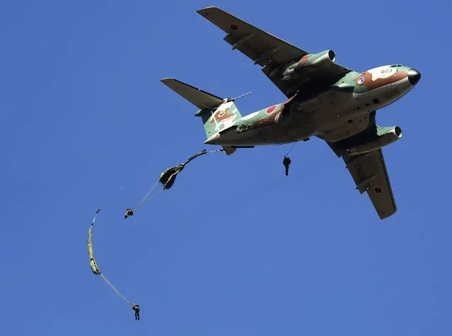 Troops from the Japan's Ground Self-Defense Force 1st Airborne Brigade dive from a C-1 transport plane during an annual new year military exercise at Narashino exercise field in Funabashi, east of Tokyo January 11, 2015. About 500 soldiers and 24 aircrafts conducted an island defense display based on a scenario of counter the military threat of invasion on Japanese territory islands by a hostile country. (Photo by Yuya Shino/Reuters)