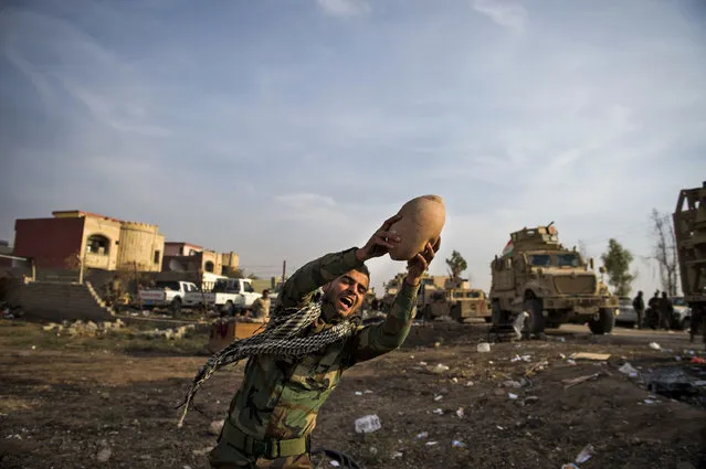 An Iraqi Kurdish Peshmerga fighter plays with the ball with comrades after returning from combat against Islamic State (IS) group jihadists in Bashiqa on November 9, 2016. Operations are still ongoing but Kurdish forces are finding less and less resistance as they move from house to house searching properties and clearing out a network of underground tunnels dug by IS linking large parts of the city. (Photo by Odd Andersen/AFP Photo)