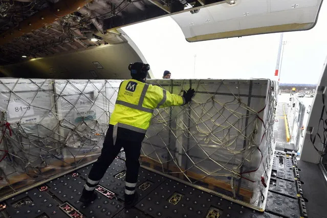 A box containing vaccines is unloaded from a Hungarian Airbus 330 cargo plane as the first batch of the vaccine against the new coronavirus produced by Sinopharm of China arrives at Budapest Liszt Ferenc International Airport in Budapest, Hungary, Tuesday, February 16, 2021. The vaccine will not be used without its examination and approval by the National Public Health Center of Hungary. (Photo by Zoltan Mathe/MTI via AP Photo)