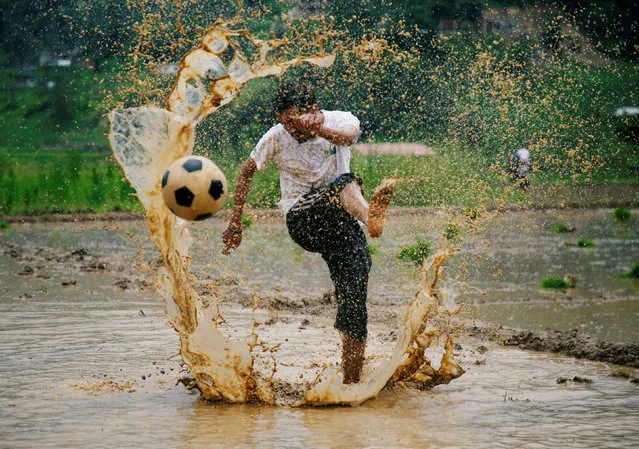 A man kicks a football as he takes part in an event celebrating National Paddy Day, also called Asar Pandra, that marks the commencement of rice crop planting in paddy fields as monsoon season arrives, in Lalitpur, Nepal, June 29, 2018. (Photo by Navesh Chitrakar/Reuters)