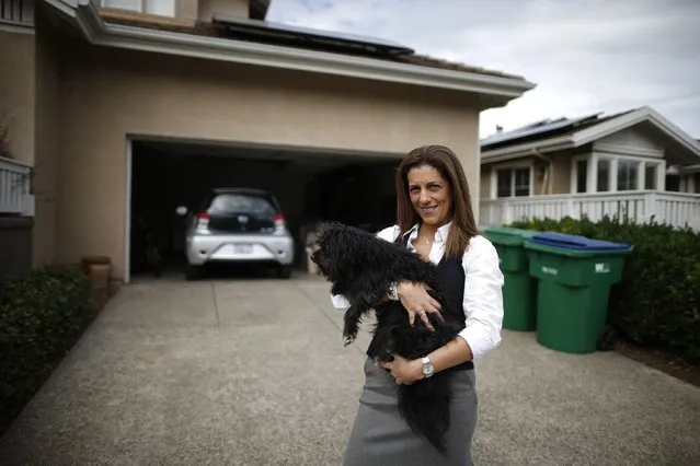 Computer science professor Christa Lopes stands next to her home and her Scion IQ electric car in Irvine, California January 26, 2015. (Photo by Lucy Nicholson/Reuters)