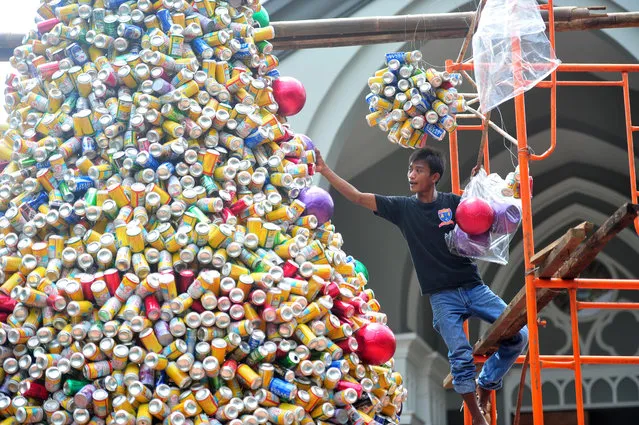A worker decorates a Christmas tree made of tin cans at the Church of Santo Laurensius in Jakarta, Indonesia, Friday, December 18, 2015. (Photo by Zulkarnain/Xinhua Press/Corbis)