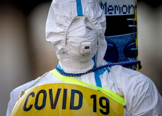 An advertising figure for Covid-19 rapid test stands in front of a small test center in Frankfurt, Germany, Sunday, March 7, 2021. From Monday on free corona tests are offered in Germany. (Photo by Michael Probst/AP Photo)