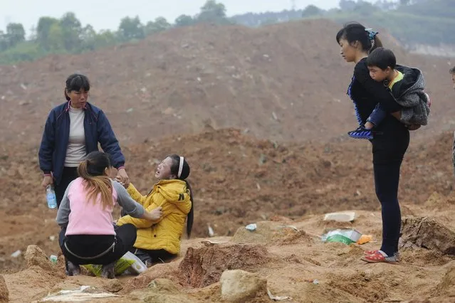 A woman (3rd L), who is a relative of several missing people, cries at the site of a landslide which hit an industrial park on Sunday in Shenzhen, Guangdong province, China, December 22, 2015. (Photo by Reuters/Stringer)