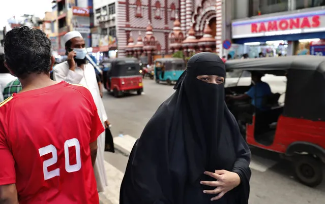 A burqa clad Sri Lankan Muslim woman walks in a street of Colombo, Sri Lanka, Saturday, March 13, 2021. Sri Lanka on Saturday announced plans to ban the wearing of burqas and said it would close more than 1,000 Islamic schools known as madrassas, citing national security. (Photo by Eranga Jayawardena/AP Photo)