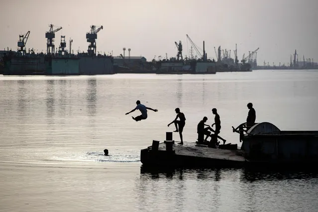 Youths swim in the Shatt al-Arab waterway, formed at the confluence of the Euphrates and Tigris rivers, in Iraq's southern city of Basra, on May 23, 2023. (Photo by Hussein Faleh/AFP Photo)