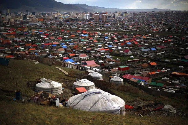 Gers, traditional Mongolian tents, are seen on a hill in an area known as a ger district in Ulan Bator June 28, 2013. Approximately 60 percent of the population of Ulan Bator live in settlements known as ger districts and in many cases residents have limited access to basic services such as water and sanitation. According to a 2010 National Population Center census, every year between thirty and forty thousand people migrate from the countryside to the capital Ulan Bator. Ger districts in the city have been expanding rapidly in recent years. Mongolia is the world's least densely populated country, with 2.8 million people spread across an area around three times the size of France. (Photo by Carlos Barria/Reuters)