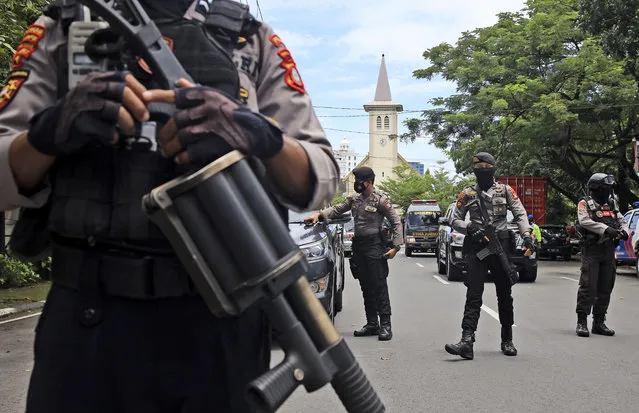 Police officers stand guard near a church where an explosion went off in Makassar, South Sulawesi, Indonesia, Sunday, March 28, 2021. Police said at least one suicide bomber detonated outside the church on Indonesia's Sulawesi island, wounding several people. (Photo by Yusuf Wahil/AP Photo)