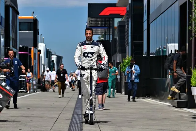Australian motorsports racing driver Daniel Ricciardo swaps his racing car for a scooter as he moves around the paddock at the Hungarian Grand Prix in Mogyorod, Hungary on July 20, 2023. (Photo by Motorsport Images/Splash News and Pictures)