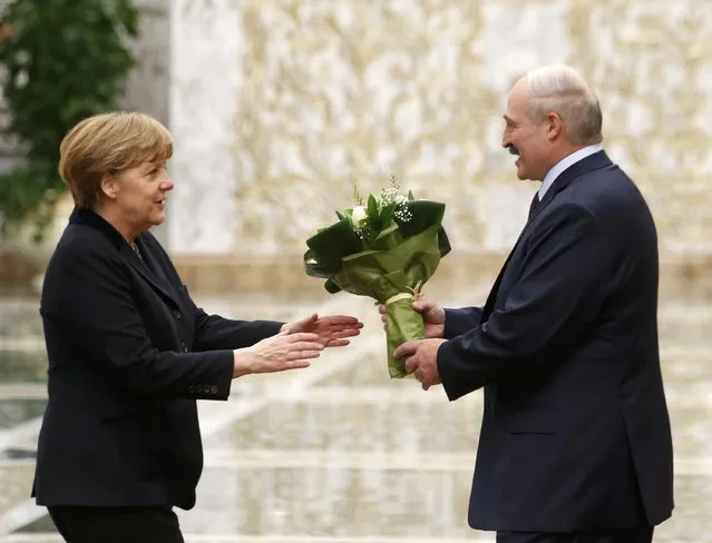 Belarus' President Alexander Lukashenko (R) welcomes Germany's Chancellor Angela Merkel during a meeting in Minsk, February 11, 2015. (Photo by Vasily Fedosenko/Reuters)