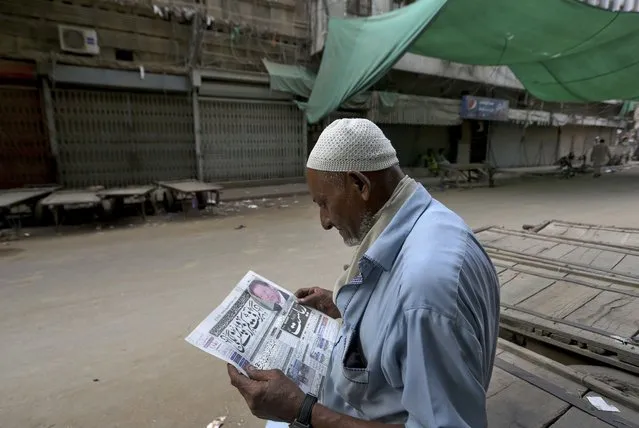 A man reads a copy of morning news paper at a market closed due to strikes called by the the country's religious political parties over the security forces's crackdown against a banned Tehreek-e-Labaik Pakistan party, in Karachi, Pakistan, Monday, April 19, 2021. (Photo by Fareed Khan/AP Photo)