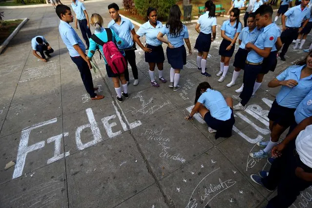 Youths write in chalk tributes to Fidel Castro in one of the cities where the caravan carrying his ashes will visit in Matanzas, Cuba, November 29, 2016. (Photo by Ivan Alvarado/Reuters)