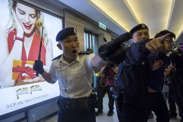 A police officer gestures at protesters during a demonstration inside a shopping mall in Hong Kong February 15, 2015. Anti-mainland Chinese demonstrators on Sunday protested against parallel traders and confronted police, government radio reported. (Photo by Tyrone Siu/Reuters)