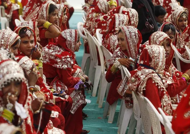 Muslim brides chat as they wait for the start of their mass marriage ceremony in the western Indian city of Ahmedabad, February 15, 2015. (Photo by Amit Dave/Reuters)