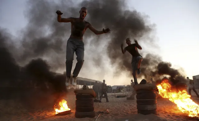 Palestinian students jump over burning tires in a display of their military skills at Al-Rebat College for Law and Police Science in Khan Younis, southern Gaza Strip, Sunday, September 23, 2018. Al-Rebat College for Law and Police Science was established by the Hamas government in 2009. 60 students participate in the training course before joining the college for four years to join the security forces in Gaza Strip. (Photo by Adel Hana/AP Photo)