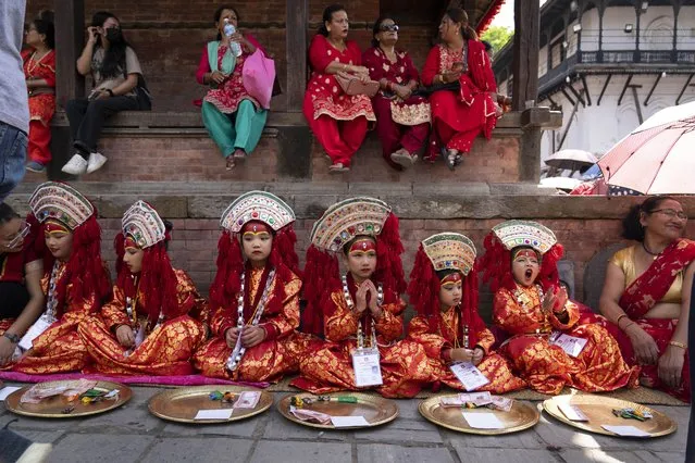 Young girls dressed as living goddess Kumari wait for Kumari Puja, a worship ritual at Hanuman Dhoka, Basantapur Durbar Square, Kathmandu, Nepal, Wednesday, September 27, 2023. Girls under the age of nine gathered for the tradition of worshiping young prepubescent girls as manifestations of the divine female energy. The ritual holds a strong religious significance in the Newar community that seeks divine blessings to save small girls from diseases and bad luck in the years to come. (Photo by Niranjan Shrestha/AP Photo)