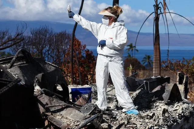 Displaced resident Lori Brodeur holds an item she found while sifting through the ashes of the wildfire destroyed home where she lived on October 05, 2023 in Lahaina, Hawaii. Volunteers from Samaritan's Purse helped Brodeur and other displaced residents search for meaningful personal items at the home. The wind-whipped wildfire on August 8th killed at least 98 people while displacing thousands more and destroying over 2,000 buildings in the historic town, most of which were homes. A phased reopening of tourist resort areas in west Maui is set to begin October 8th on the two-month anniversary of the deadliest wildfire in modern U.S. history. Many local residents feel that the community needs more time to grieve and heal before reopening to tourists while the Maui economy is estimated to be losing around $13 million per day to lost tourism. (Photo by Mario Tama/Getty Images)