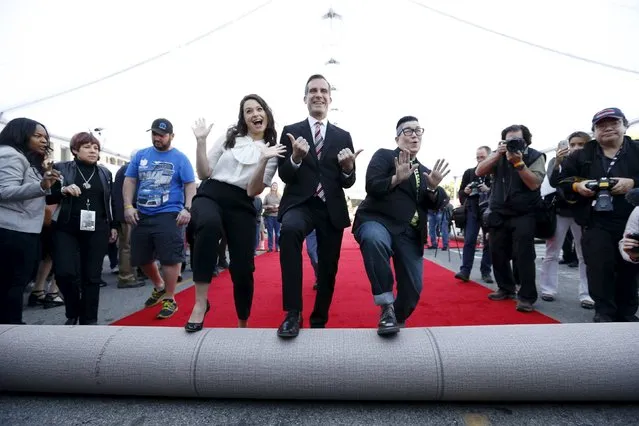 Los Angeles Mayor Eric Garcetti with actresses Katie Lowes (L) and Lea DeLaria symbolically roll out red carpet during preparations for the 22nd annual Screen Actors Guild Awards at the Shrine Auditorium in Los Angeles, California January 29, 2016. The Awards will be given out in Los Angeles on January 30. (Photo by Mario Anzuoni/Reuters)