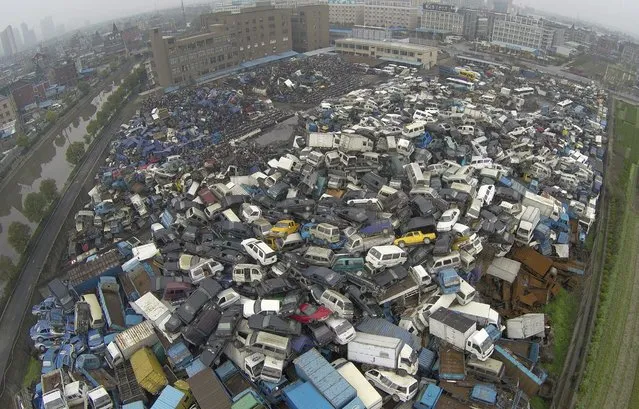 Scrapped vehicles are piled up at a parking lot used as a scrapyard in Hangzhou, Zhejiang province, March 19, 2015. (Photo by Reuters/China Daily)