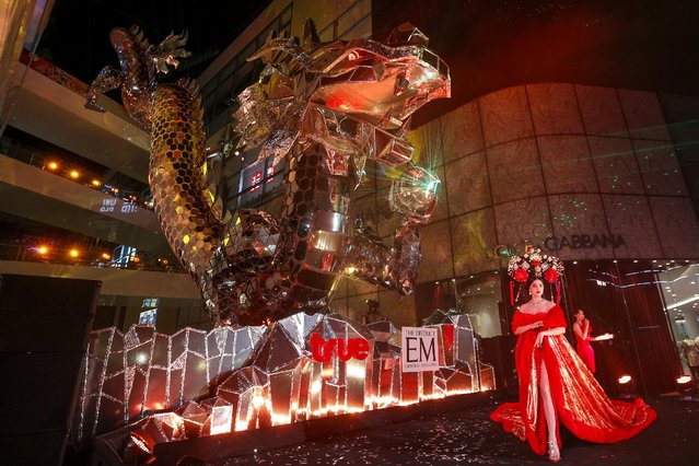 An artist performs next to a giant dragon sculpture as part of the festive Chinese Lunar New Year celebrations in Bangkok's shopping district, Thailand, February 4, 2016. (Photo by Athit Perawongmetha/Reuters)
