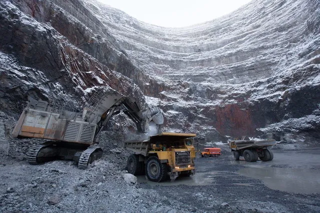 An excavator loads a dump truck with diamond ore at the base of the open pit at the Udachny diamond mine operated by OAO Alrosa in Udachny, Russia, on Sunday, November 17, 2013. (Photo by Andrey Rudakov/Bloomberg)