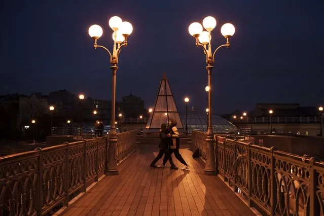 A couple dances on a footbridge near the Independence Square in Kyiv, Ukraine, Tuesday, November 21, 2023. (Photo by Felipe Dana/AP Photo)