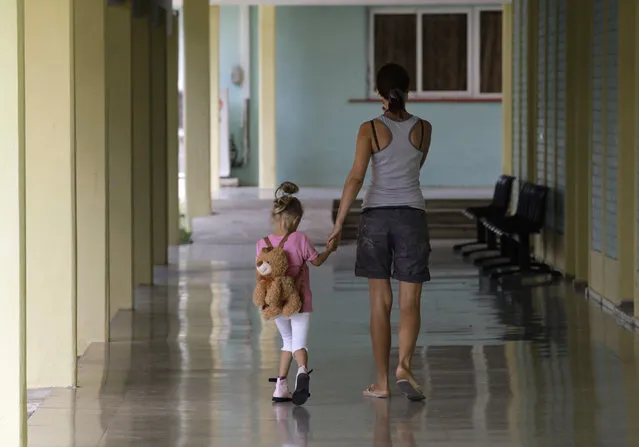 A Ukrainian girl, Olga, 2, victim of the 1986 nuclear power plant disaster in Chernobyl, walks with a Cuban physiotherapist at the Pediatric Hospital in Tarara, outside Havana, March 2010. (Photo by Desmond Boylan/Reuters)