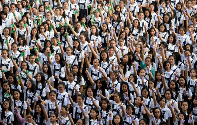 Students of St. Scholastica's College gesture the “number one” sign as they dance to take part in the “One Billion Rising” campaign in Manila on February 15, 2016. The campaign, the fifth to be held since 2012, calls for the end of all forms of discrimination and violence against women and girls. The movement refers to UN statistics that one in 3 women, about one billion globally, will be raped or beaten in their lifetime. (Photo by Noel Celis/AFP Photo)