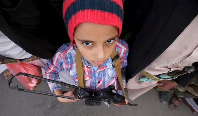 A boy, who is a follower of the Houthi movement, carries his weapon during a protest against the Saudi-led air strikes in Sanaa April 10, 2015. (Photo by Mohamed al-Sayaghi/Reuters)