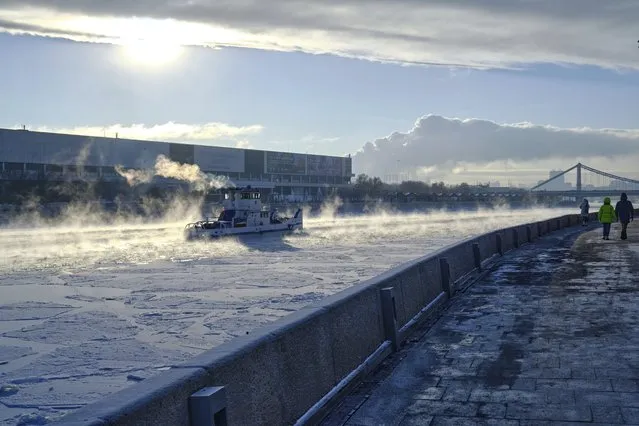 An Icebreaker operates on the frozen Moscow River during a cold winter day in Moscow, Russia, Friday, January 5, 2024. The Russian capital is basking in unusually cold winter weather as temperatures reached around –18 C (–0,4 F) during a day and –20 C (–4 F) at night. (Photo by Yuri Degtyarev/AP Photo)