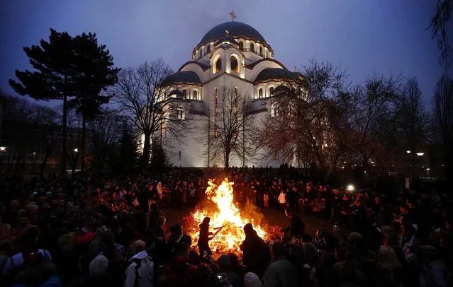 People burn dried oak branches, which symbolize the Yule log, on Orthodox Christmas Eve in front of the St. Sava temple in Belgrade, on January 6, 2014. Serbian Orthodox Christians celebrate Christmas on January 7, according to the Julian calendar. (Photo by Marko Djurica/Reuters)