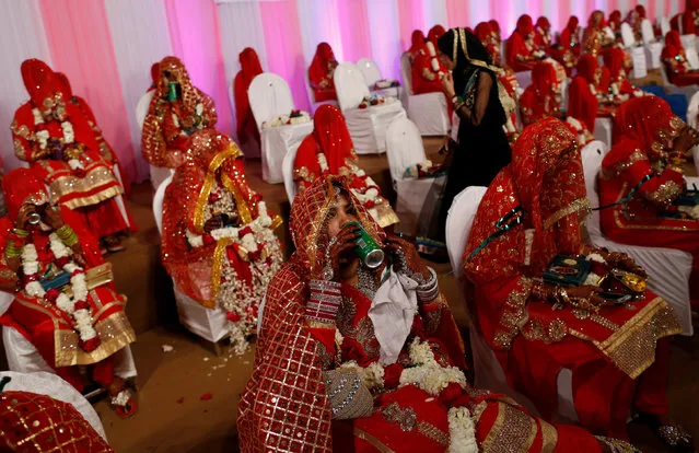 A bride drinks refreshment during a mass marriage ceremony, in which, according to its organizers, 75 Muslim couples took their wedding vows, in Mumbai, India, January 22, 2017. (Photo by Danish Siddiqui/Reuters)