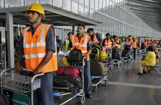 Members of India's Second Battalion National Disaster Response Force (NDRF) stand in a queue as they leave for Kathmandu to assist in the search and rescue operation, at Netaji Subhas Chandra Bose international airport in Kolkata, India, Monday, April 27, 2015. (Photo by Bikas Das/AP Photo)