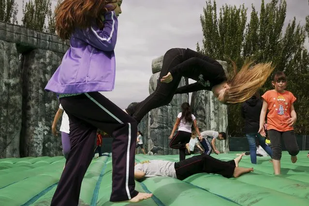 Children play on an inflatable replica of Stonehenge at a public park in Mostoles, Spain, April  27, 2015. (Photo by Susana Vera/Reuters)