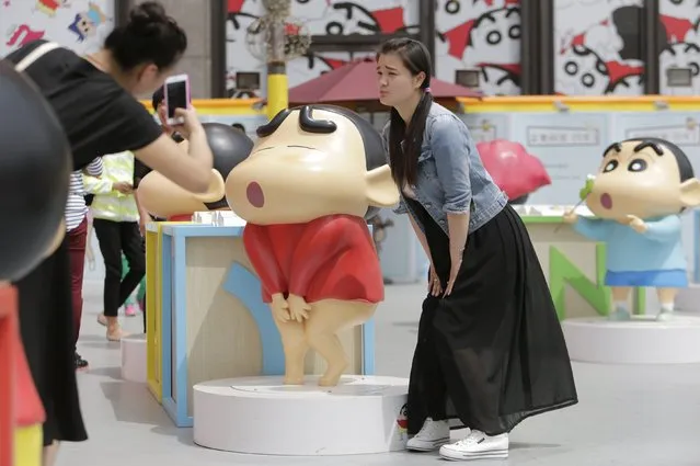 A visitor poses for a photo with a Crayon Shin-chan model during an exhibition at Joy City in Beijing May 5, 2015. (Photo by Jason Lee/Reuters)