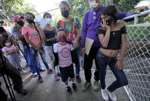 Venezuelans citizen wait in line to receive a dose of a COVID-19 vaccine in La Parada, near Cucuta, Colombia, Friday, November 12, 2021. Over the past two weeks Colombia has provided COVID-19 vaccines to thousands of Venezuelans. (Photo by Fernando Vergara/AP Photo)
