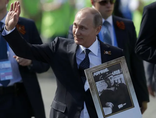 Russian President Vladimir Putin holds the portrait of his father as he takes part in the Immortal Regiment march on the Red Square during the Victory Day celebrations in Moscow, Russia, May 9, 2015. (Photo by Maxim Shemetov/Reuters)