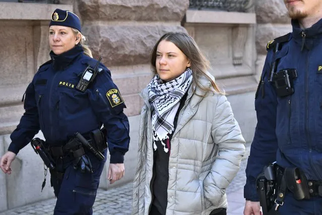 Swedish climate activist Greta Thunberg (C) is led away by police after being arrested during a sit in outside the Swedish parliament, the Riksdagen, to demonstrate for climate action, on March 12, 2024 in Stockholm, Sweden. (Photo by Samuel Steen/TT News Agency via AFP Photo)