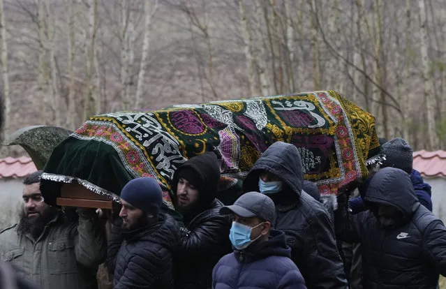 A local Muslim community buried a Yemeni migrant Mustafa Mohammed Murshed Al-Raimi, in Bohoniki, Poland, Sunday, November 21, 2021. The person is one of about a dozen people from the Middle East and elsewhere who have died in a area of forests and bogs along the Poland-Belarus border amid a standoff involving migrants between the two countries. The burial took place in Muslim cemetery in Bohoniki, where a population of Muslim Tatars has lived for centuries. It was the second funeral which community members have performed for a migrant in the past week. (Photo by Czarek Sokolowski/AP Photo)