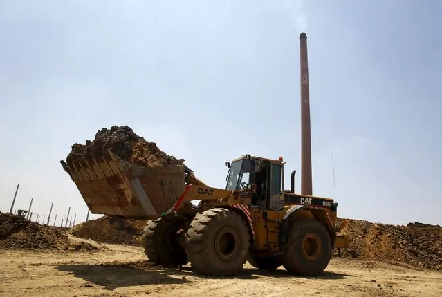 A loader transports sand for brick-making at a traditional bricks factory in Arab Mesad district of Helwan, northeast of Cairo, May 14, 2015. (Photo by Amr Abdallah Dalsh/Reuters)