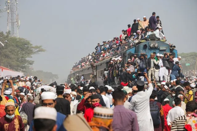 Muslim devotees leap between carriages to be the first to find any kind of space on their train back home following three days of prayer on January 15, 2023. Tens of thousands of Muslims had gathered for prayer in Tongi, Dhaka, Bangladesh as part of Ijtema a three day event which is celebrated as Tablighi Jamaat around the world. During Ijtema, the government stops most forms of travel other than trains. For this reason, the trains are overcrowded. (Photo by Shafiul Alam/Solent News/Rex Features/Shutterstock)