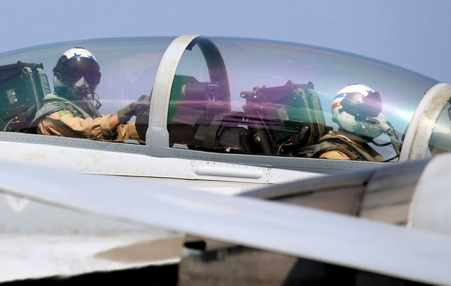 U.S. navy pilots are pictured inside the cockpit of F18 fighter jet moments before flying over the South China Sea, March 3, 2017. (Photo by Erik De Castro/Reuters)
