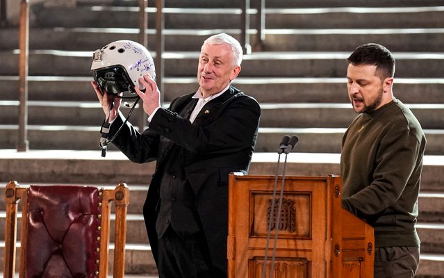 Speaker of the House of Commons, Sir Lindsay Hoyle (L), holds up the helmet of one of the most successful Ukrainian pilots, inscribed with the words “We have freedom, give us wings to protect it”, which was presented to him by Ukrainian President Volodymyr Zelensky as he addressed parliamentarians in Westminster Hall on February 8, 2023 in London, England. The Ukrainian President makes a surprise visit to the UK today in his second visit outside Ukraine since the Russian invasion nearly a year ago. The UK will offer further support in the form of training, equipment and Russian sanctions. (Photo Stefan Rousseau-by WPA Pool/Getty Images)