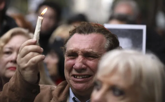 A man cries as he holds up a candle on the 25th anniversary of the bombing of the AMIA Jewish center that killed 85 people in Buenos Aires, Argentina, Thursday, July 18, 2019. (Photo by Natacha Pisarenko/AP Photo)