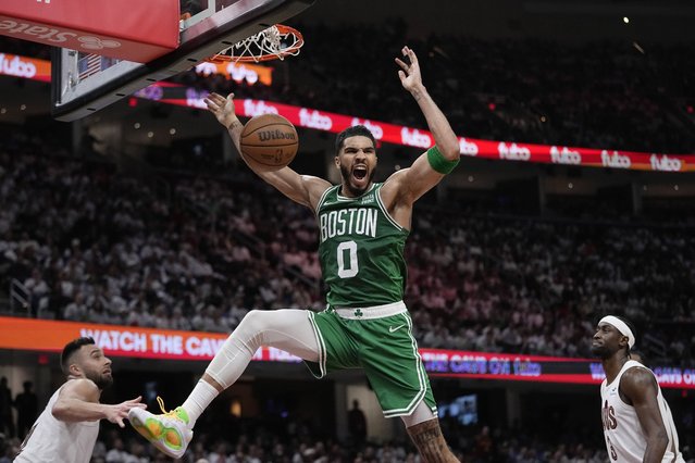 Boston Celtics forward Jayson Tatum dunks between Cleveland Cavaliers guard Max Strus, left, and guard Caris LeVert during the second half of Game 3 of an NBA basketball second-round playoff series Saturday, May 11, 2024, in Cleveland. (Photo by Sue Ogrocki/AP Photo)