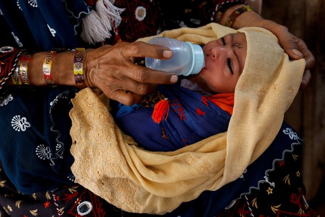 A mother gives water to her six-day-old baby, Darya Khan, to cool off during a hot summer day as the heatwave continues in Jacobabad, Pakistan on May 25, 2024. (Photo by Akhtar Soomro/Reuters)