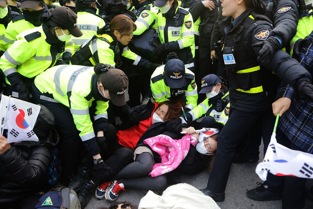Police officers scuffle with protesters as they demand the arrest of ousted South Korean President Park Geun-hye, in front of her private home on March 30, 2017 in Seoul, South Korea. A hearing to determine whether an arrest warrant should be issued for former president Park Geun-hye will be held at the Seoul Central District Court.  (Photo by Chung Sung-Jun/Getty Images)