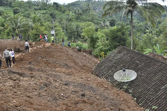 Rescuers search for victims in a neighborhood hit by a landslide in the village of Banaran, Ponorogo, East Java, Indonesia, Saturday, April 1, 2017. More than two dozen people were reported missing on Saturday after the rain-triggered landslide struck a village on Indonesia's main island of Java. (Photo by AP Photo/Firdaus)