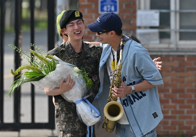 K-pop boy band BTS member Jin (L) is greeted by fellow BTS member RM (R) after being discharged from his mandatory military service outside a military base in Yeoncheon on June 12, 2024. K-pop megastar Jin from BTS was discharged from his South Korean military service on June 12, AFP reporters saw, the first member of the band to complete the mandatory duty, freeing him up to fully resume musical activities. (Photo by Jung Yeon-je/AFP Photo)
