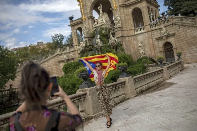 An Ukranian tourist poses for a snapshot with a Catalan independence flag during the Catalan National Day in Barcelona, Spain, Wednesday, September 11, 2019. The traditional September 11, called “Diada”, marks the fall of Barcelona to Spanish forces in 1714. (Photo by Bernat Armangue/*AP Photo)